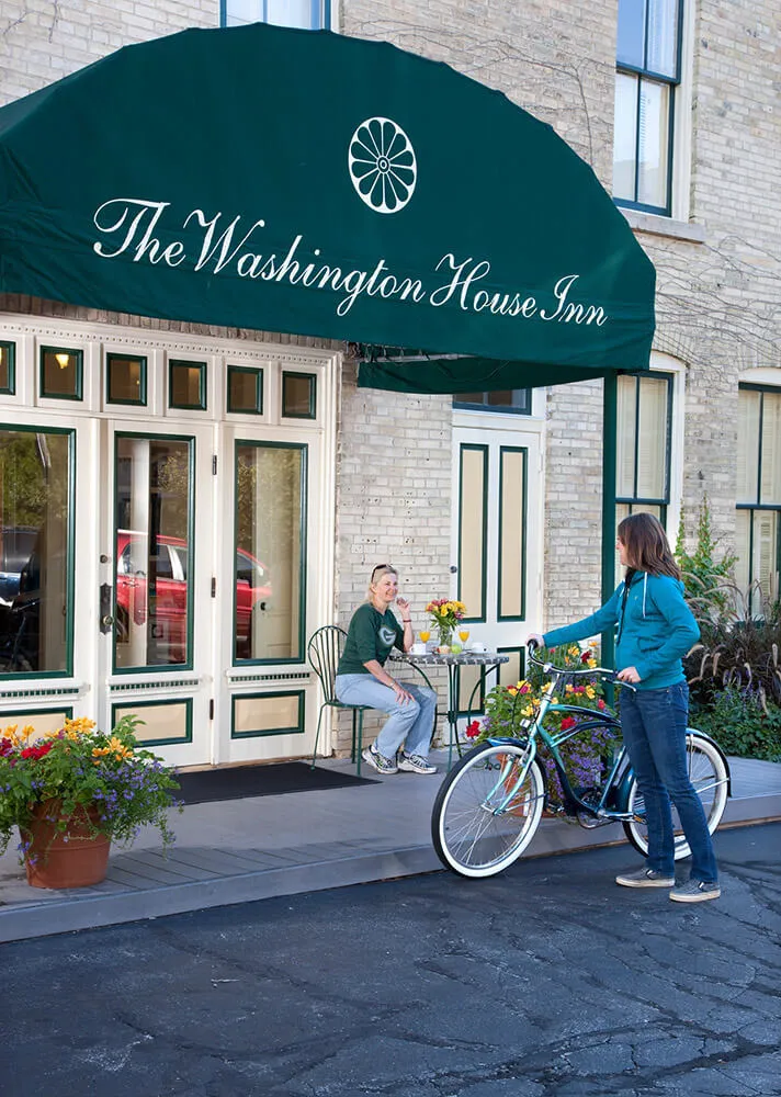 Woman with a bike in front of the Washington House Inn